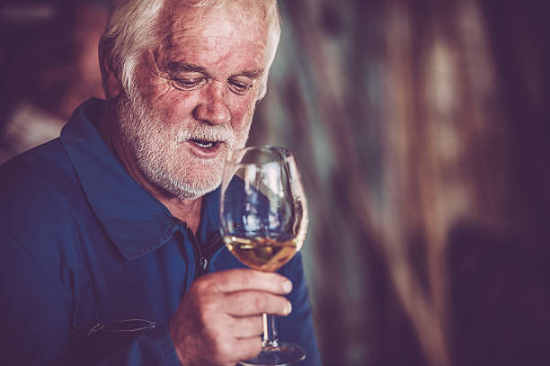 istock Senior Man with Beard Drinking Glass of White Wine 579772696