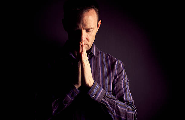 istock Man praying in the dark 579772746