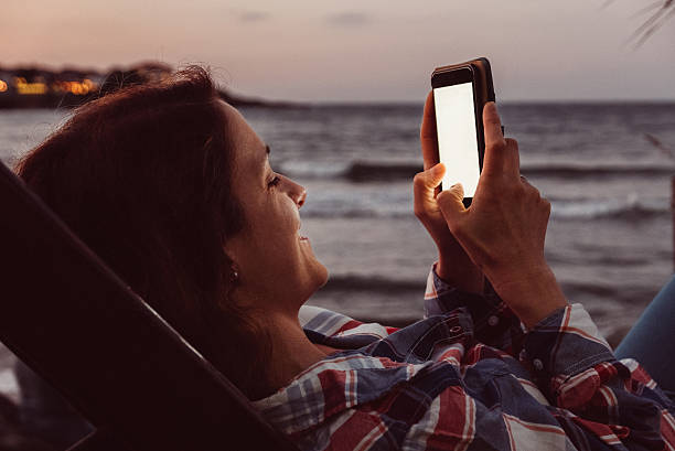 istock Woman at the beach texting 579773040