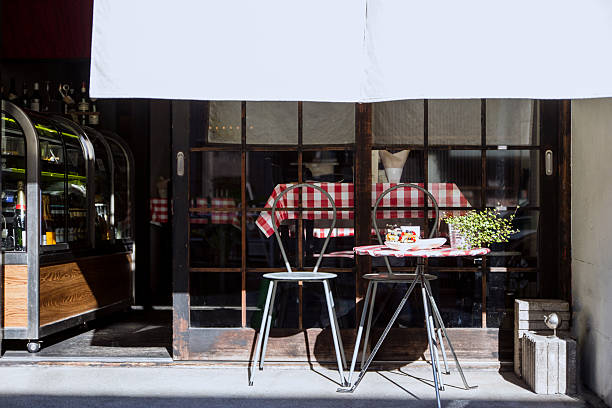 This is the entrance part of a restaurant in Tokyo, Japan, The showcase and tables are inside the restaurant. A small table and two chairs are outside of the restaurant.