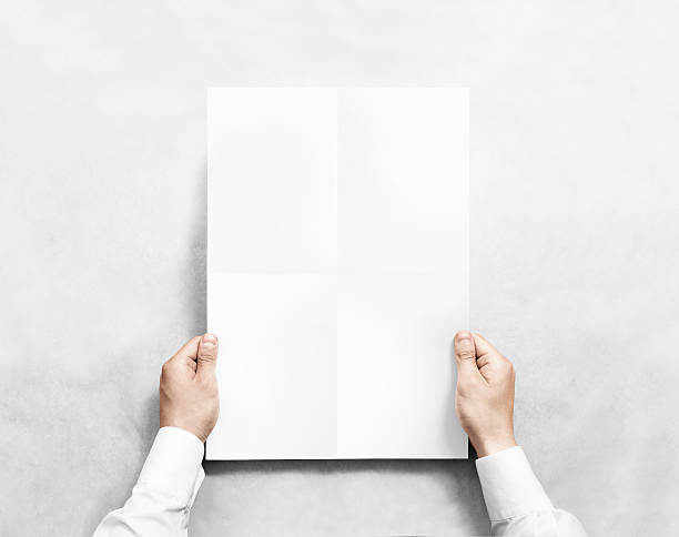 istock Hand holding white blank poster mockup, isolated. 579774162