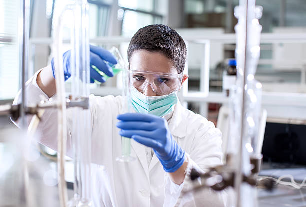 istock Scientist pouring a chemical into a measuring cylinder 579776334