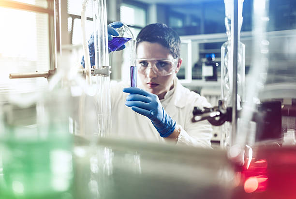 Scientist pouring a reagent into a measuring cylinder