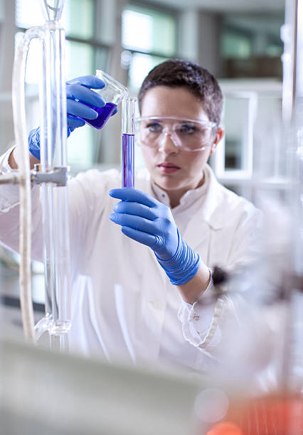 istock Scientist pouring a reagent into a measuring cylinder 579776346