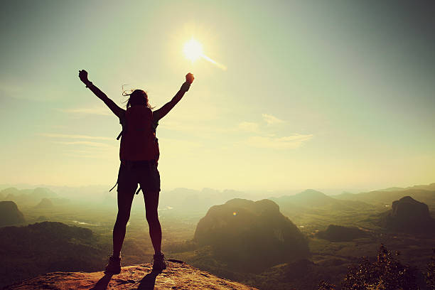 istock cheering woman hiker at sunrise mountain peak 579778442