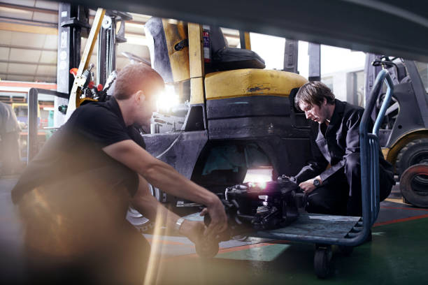 istock Mechanics fixing forklift in auto repair shop 579980573