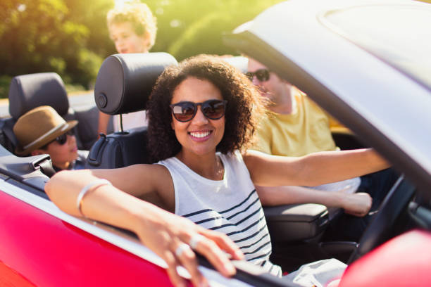 portret entuzjastycznej kobiety prowadzącej kabriolet z rodziną - fun mother sunglasses family zdjęcia i obrazy z banku zdjęć