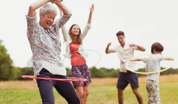 istock Playful multi-generation family spinning in plastic hoops in field 579980791