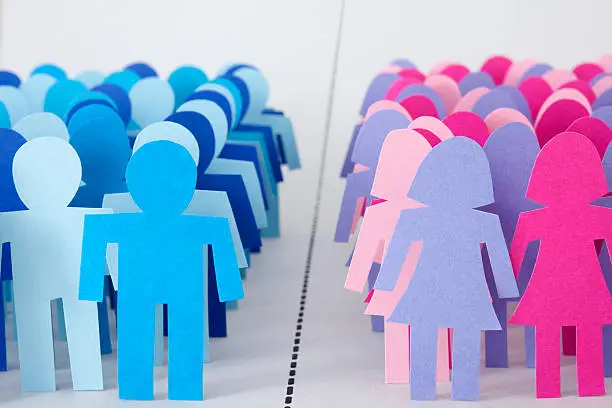 Conceptual image of paper men and women silhouettes divided by dotted line