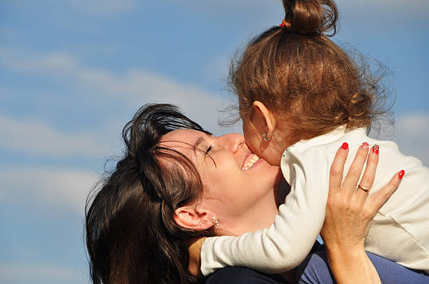 istock Happy mother hugging her daughter against the sky 580092044