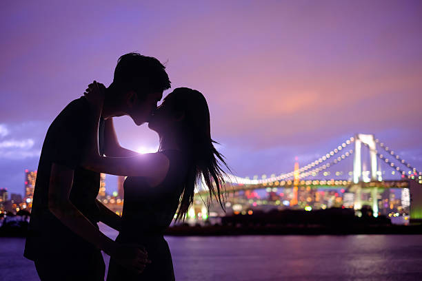 A beautifully romantic moment was captured between an affectionate couple, framed by a stunning bridge backdrop. Manhattan and Brooklyn bridge in New York.
