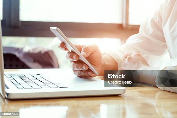 Businessman Using Laptop And Mobile Phone Stock Photo - Download Image Now - Banking, Business, Business Finance and Industry