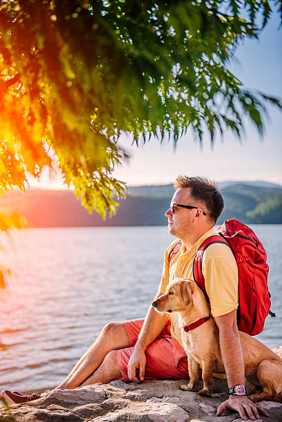 istock Man and dog enjoying sunset 580102390