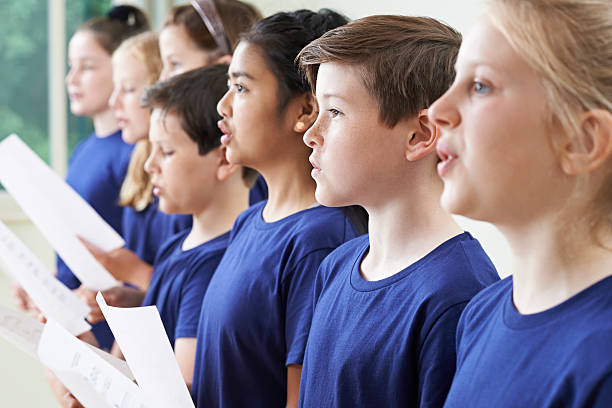 grupo de crianças da escola em coro cantar junto  - sheet music music classroom education - fotografias e filmes do acervo