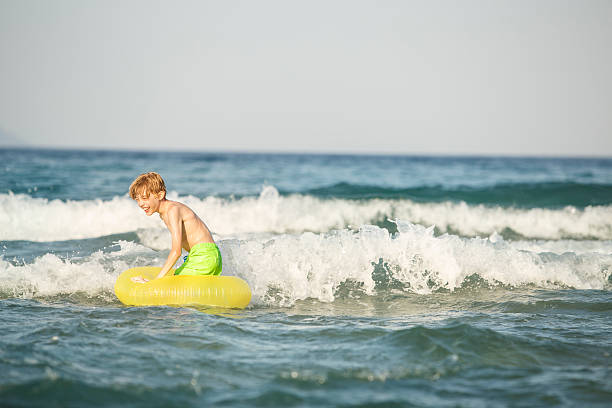 istock Boy in inflatable ring having fun, swimming 580105702