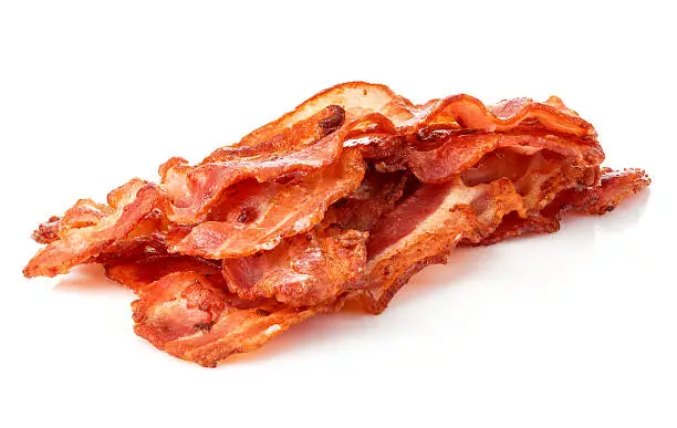 Photo of Cooked bacon rashers close-up isolated on a white background.