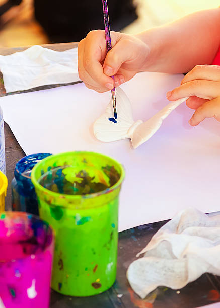 istock Girl paints a butterfly 580107614