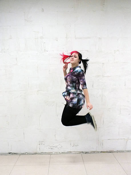 Cheerful girl jumping against a white wall Jumping, Student, Cheerful, Happiness, White Background black hair emo girl stock pictures, royalty-free photos & images
