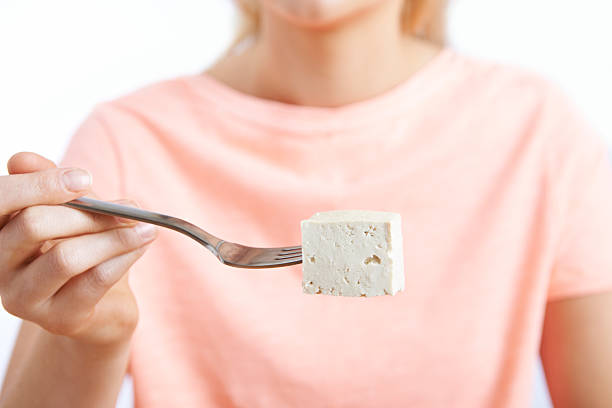 Close Up Of Woman With Tofu On Fork stock photo