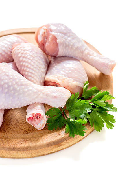 istock Chicken drumsticks and parsley on a wooden board. 580110798