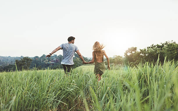 istock Young couple running on meadow 580110974