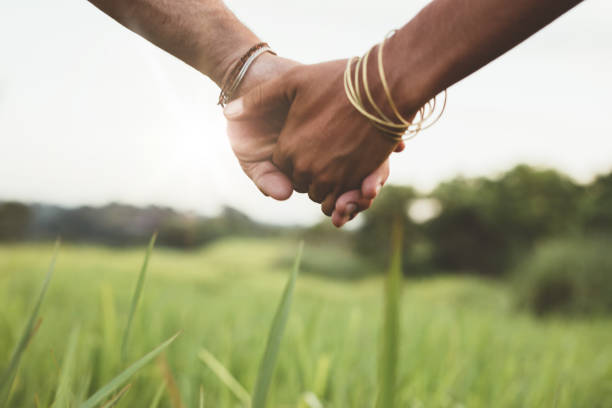 istock Young couple holding hands in the field 580111196