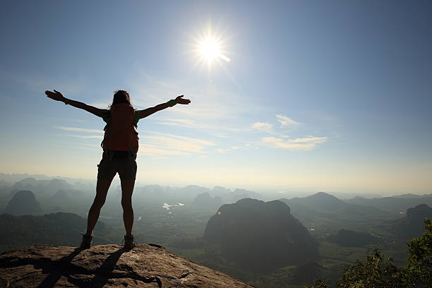 istock cheering woman hiker at sunrise mountain peak 580111352