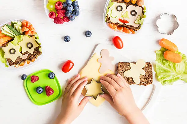 Photo of School lunch box for kids. Cooking. Child's hands. Flat lay