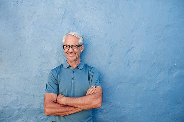 istock Happy mature man standing with his arms crossed 580112944