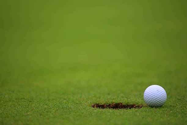 istock Golf ball on lip of cup 580113798