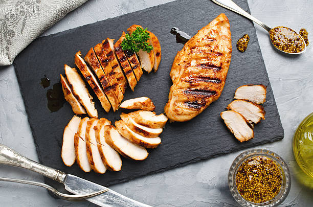 Grilled chicken fillets in a spicy marinade Grilled chicken fillets on slate plate. Gray concrete background cooked stock pictures, royalty-free photos & images