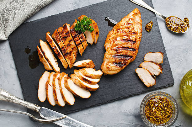 Grilled chicken fillets in a spicy marinade Grilled chicken fillets on slate plate. Gray concrete background Poultry stock pictures, royalty-free photos & images