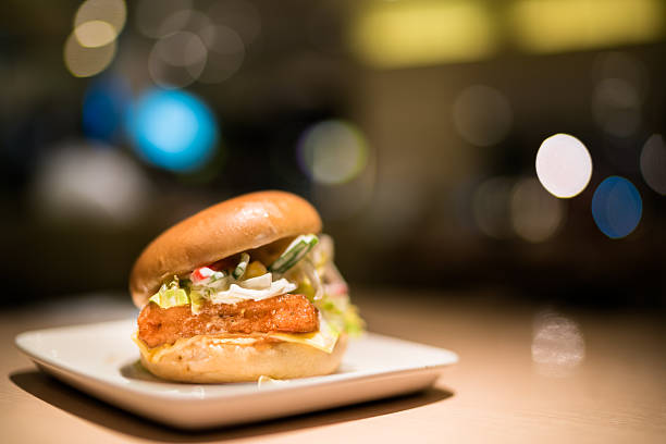 Fried fish burger under spotlight, blur bokeh dark background