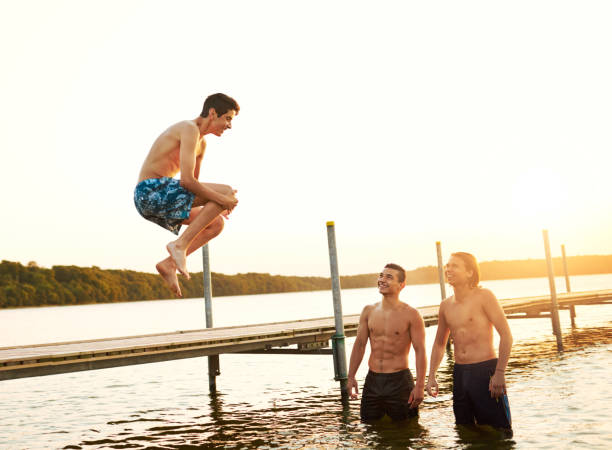 istock Teenage boy jumping into a lake 580114864