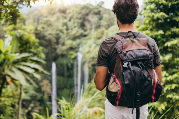 istock Young male hiker admiring the waterfall 580115594