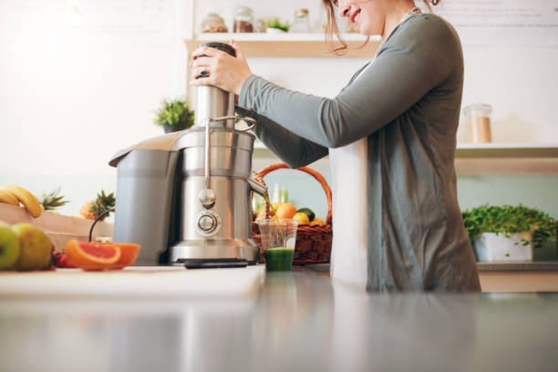 과일 주스를 만드는 젊은 여성 바 직원 - electric juicer 뉴스 사진 이미지