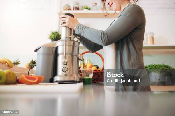 Young Female Bar Employee Making Fruit Juice Stock Photo - Download Image Now - Juicer, Electric Juicer, Food Processor