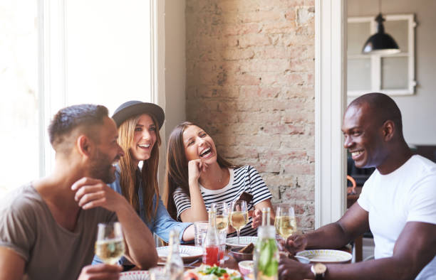 istock Four happy friends having wine and dinner together 580115886