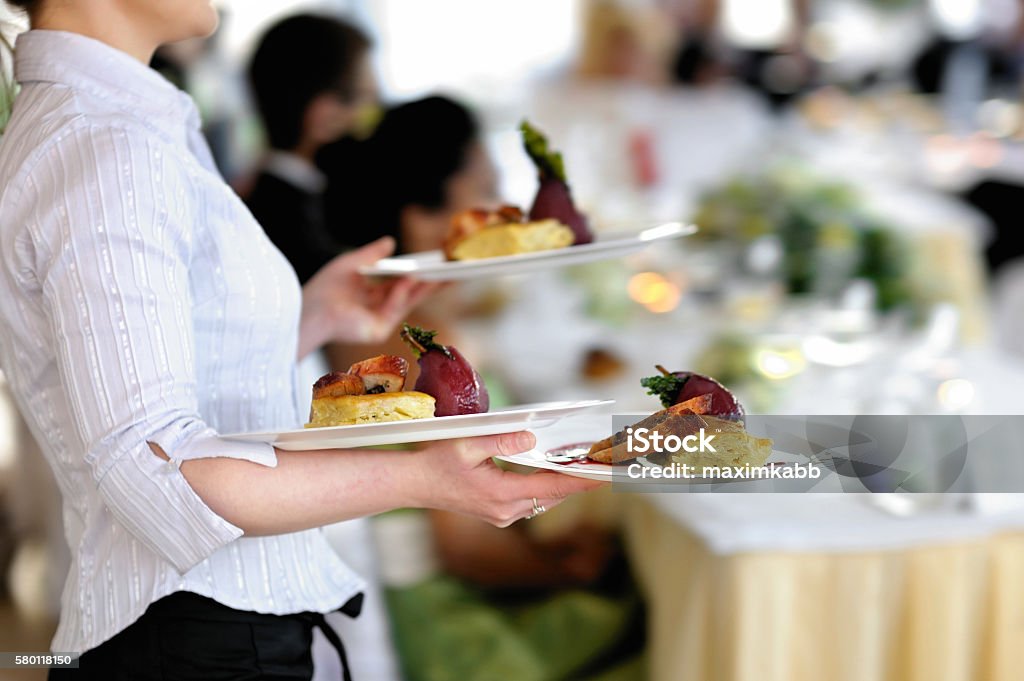 Camarera lleva tres platos - Foto de stock de Camarero libre de derechos