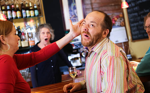 Woman Slaps Funny Man in Bar Woman slaps a man in a bar, while another woman looks on with a shocked expression. Some humor involved! vex nightclub stock pictures, royalty-free photos & images