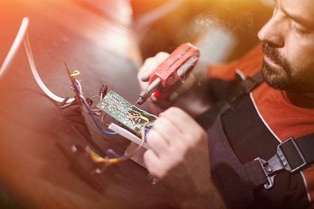 istock Repairman working in workshop and soldering electric board 580119470