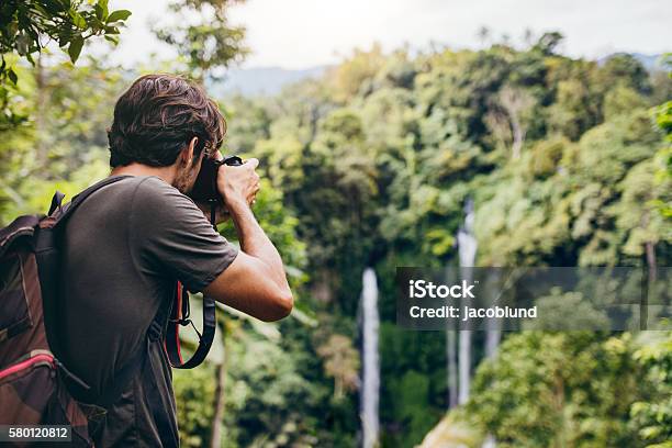 Excursionista Masculino Fotografiando Una Cascada En El Bosque Foto de stock y más banco de imágenes de Fotógrafo