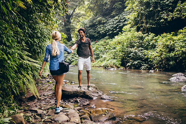istock Young couple walking by the mountain stream 580120892