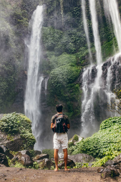 istock Young male hiker looking at waterfall 580121234