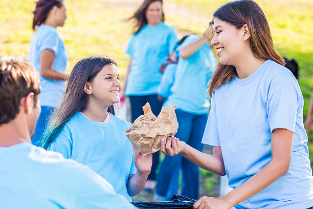 istock Mother and daughter help clean up their community 580121290