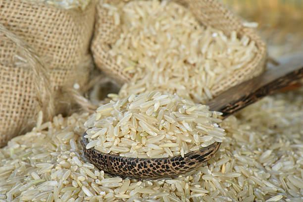 riso integrale da primo piano su cucchiaio di legno - brown rice rice brown scoop foto e immagini stock