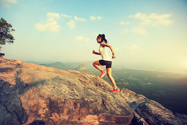 istock young asian woman runner running on mountain peak 580129418