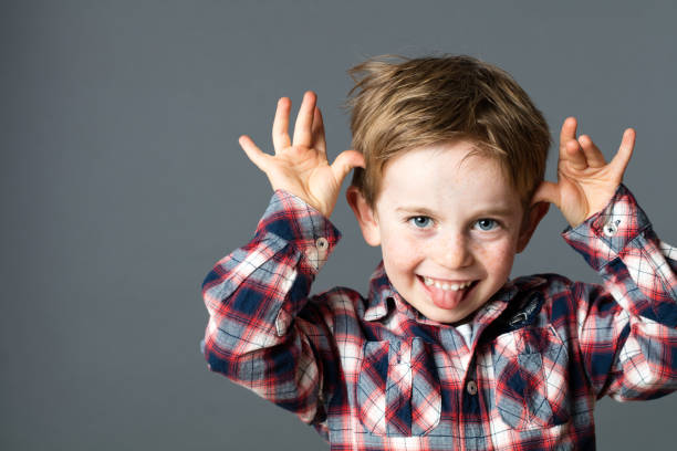 istock smiling young kid sticking out his tongue, playing with hands 580131532