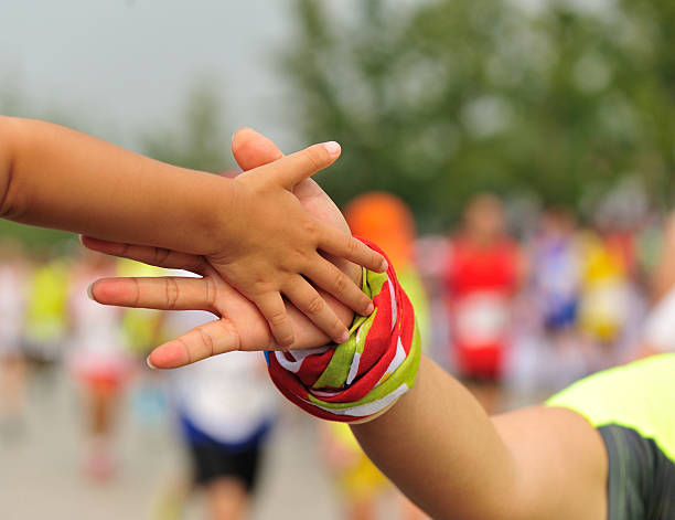 istock marathon runner clap hand with child spectators 580132894