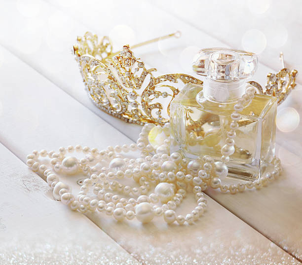 istock White pearls necklace, diamond tiara and perfume bottle 580134026